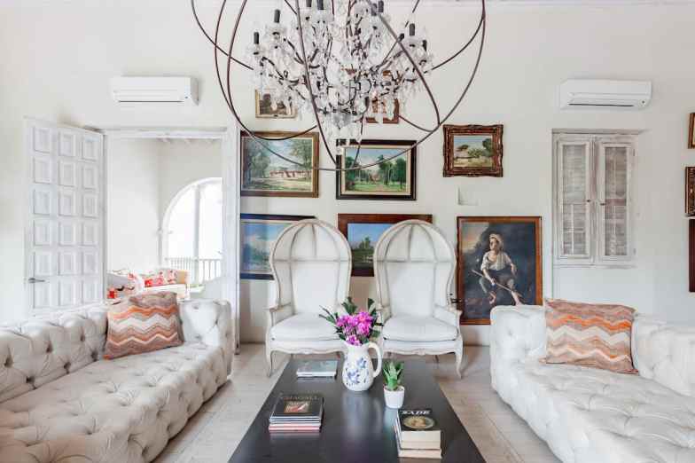 Airy, white living space with artwork and two couches