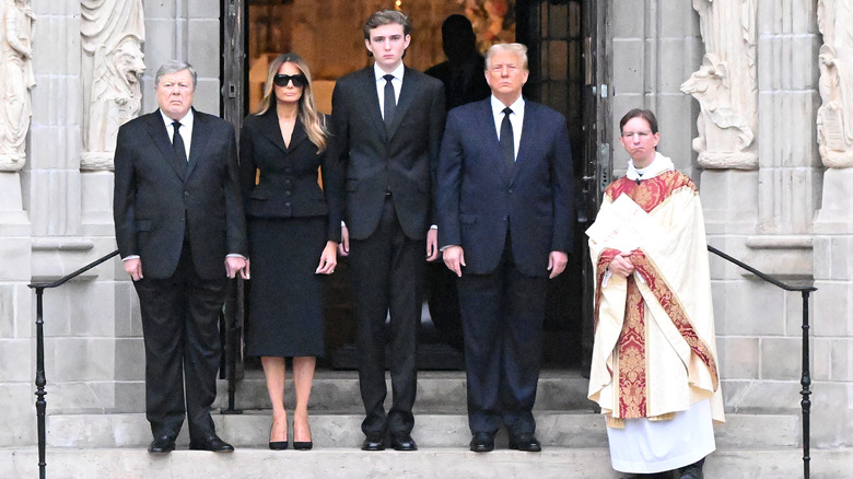 Barron Trump on steps between parents