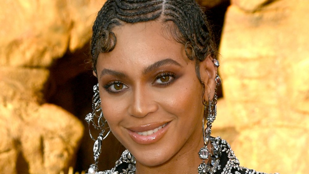 Beyoncé in a sparkly black outfit, smiling at The Lion King premiere