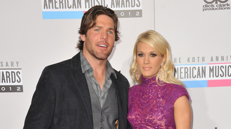 Carrie Underwood and Mike Fisher pose together on red carpet