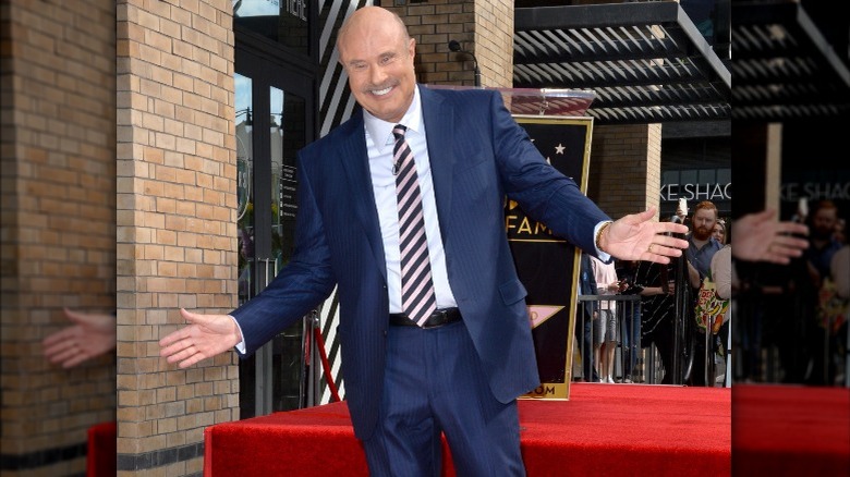 Dr. Phil with arms outstretched in 2020