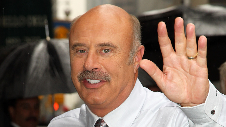 Dr. Phil waves to photographers