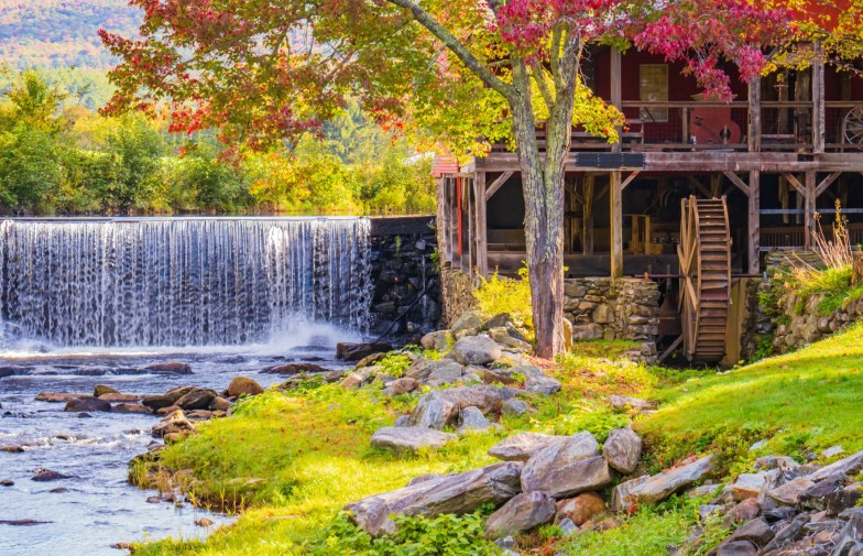 The old Mill Museum, water wheel, millpond and waterfall in Weston Village in Vermont