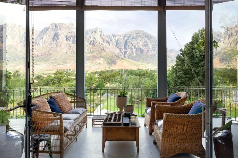 Living room with floor to ceiling glass windows and mountain backdrop