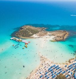 Aerial view of a beach with umbrellas and turquoise water