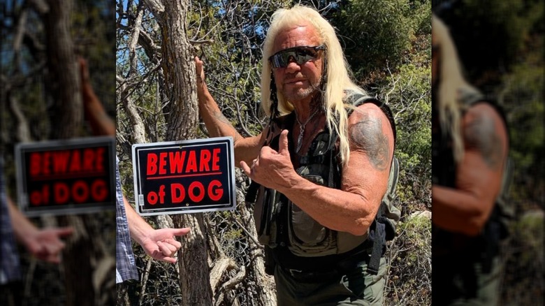 Dog the Bounty Hunter posing with sign