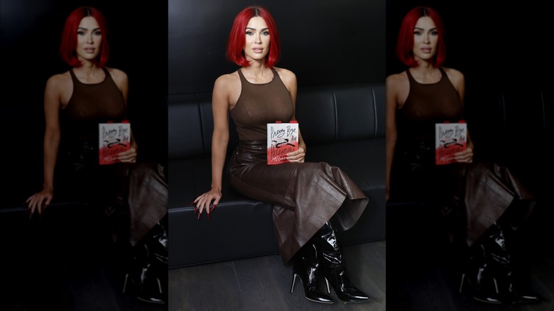 Megan Fox seated and holding book