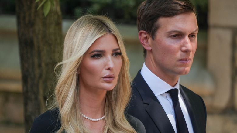 Ivanka Trump and Jared Kushner walking with somber expressions