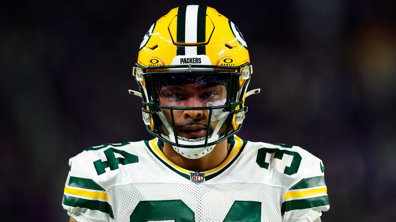 Jonathan Owens wearing a yellow football helmet and white, green, and yellow jersey