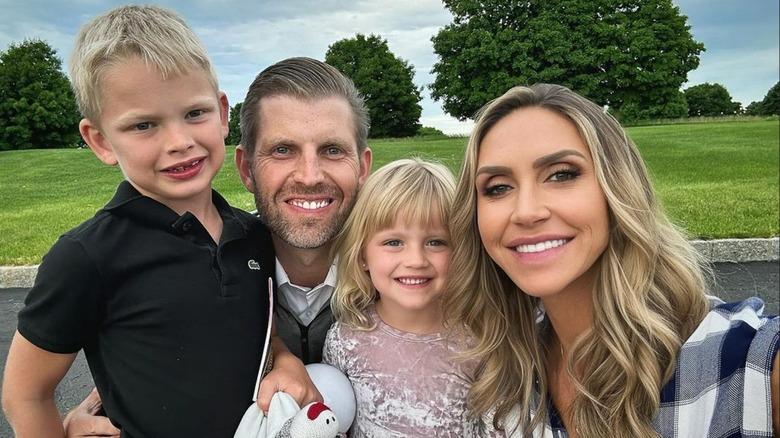 Lara and Eric Trump smiling outdoors with kids