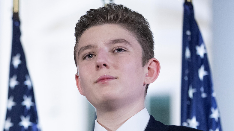 Barron Trump in front of American flags