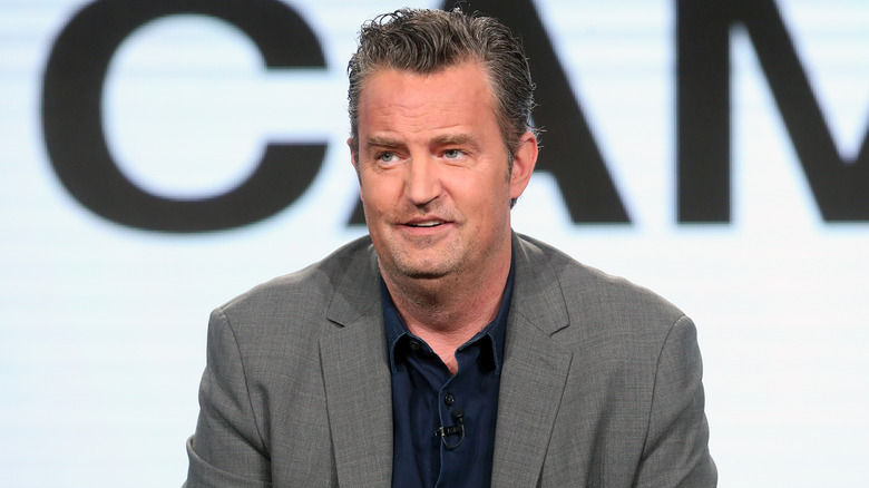 Matthew Perry wearing a gray jacket