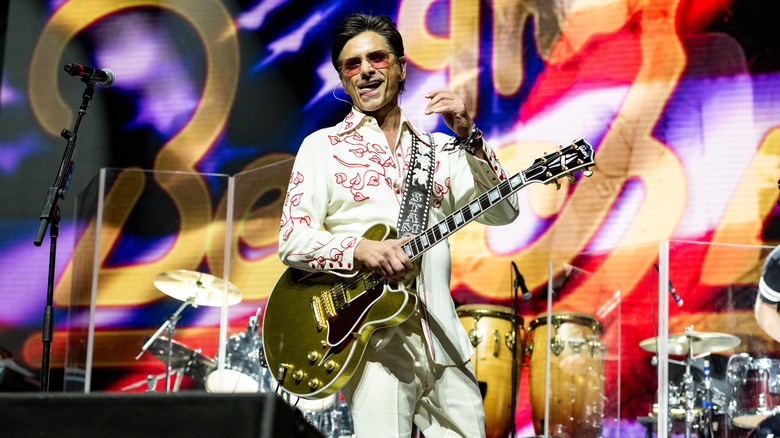 John Stamos holding gold guitar