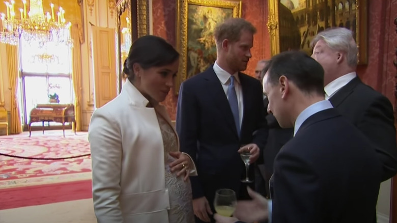 Meghan Markle and Prince Harry talking to men