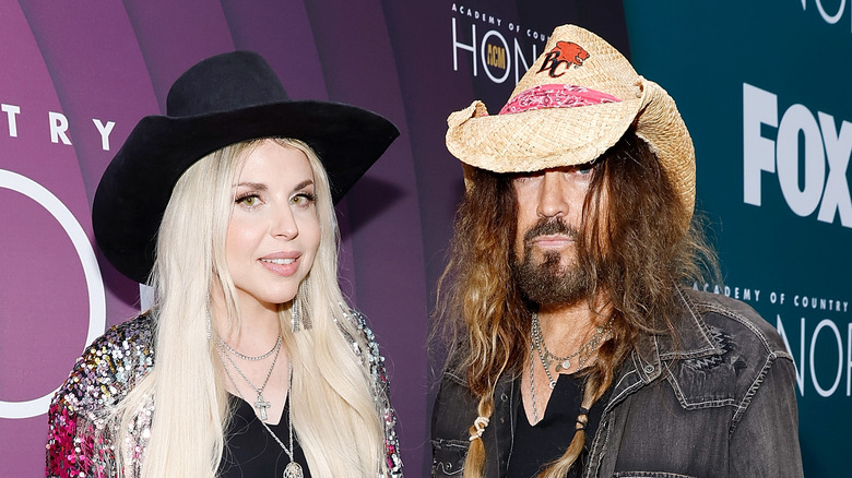 Firerose and Billy Ray Cyrus stand together in cowboy hats