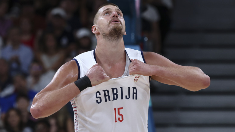 Nikola Jokic pulling at his shirt