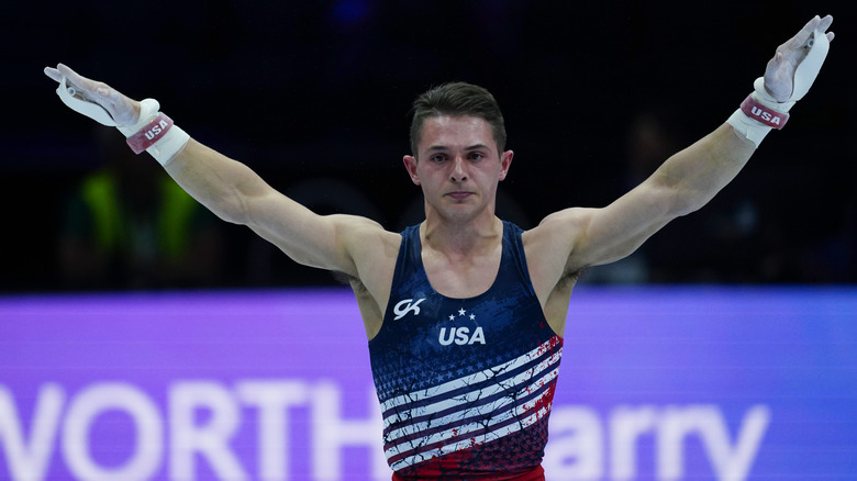 Paul Juda holding his hands up wearing wrist guards and a blue USA-adorned tank top