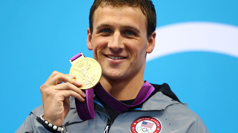 Ryan Lochte posing with his gold medal