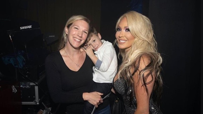 Bunnie Xo smiling with Jelly Roll's son and his mother