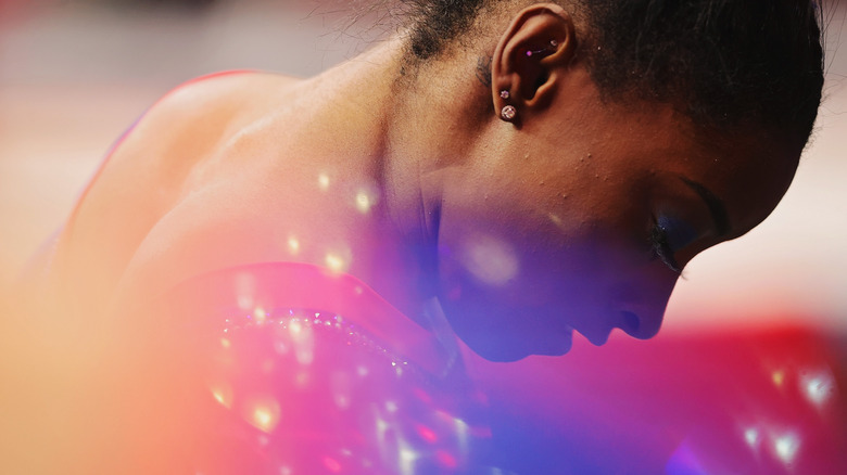 Simone Biles, looking down