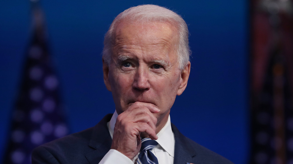 Joe Biden holding his hand to his mouth