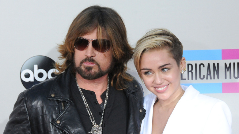 Billy Ray and Miley Cyrus pose on red carpet